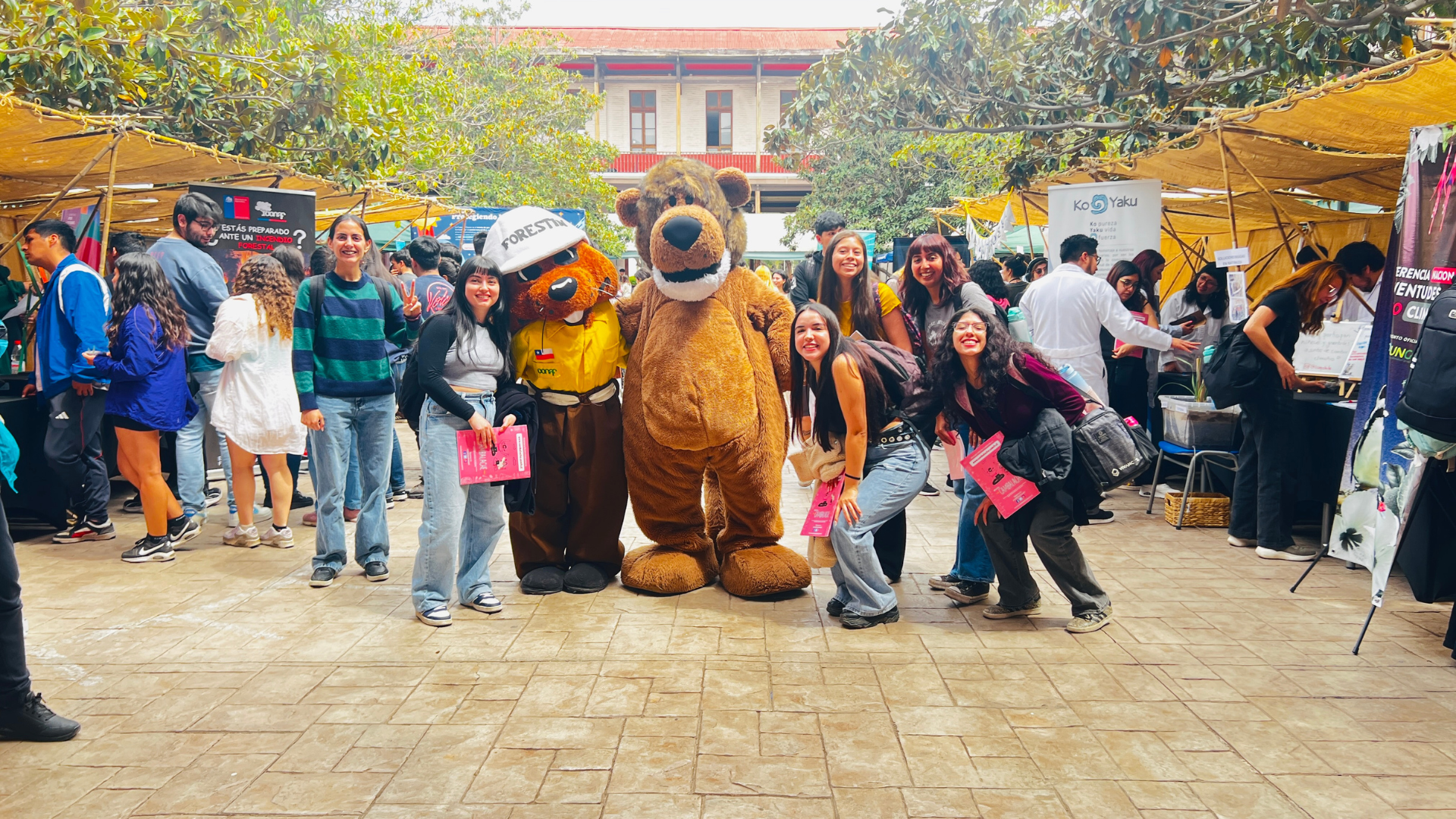 estudiantes usach sacandose una fotografia con la mascota institucional de la Universidad y con la mascota de Conaf