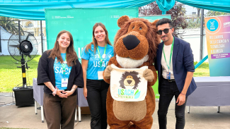 Staff stand de Usach Sostenible junto a Usachín (mascota institucional de la USACH)