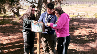 Estudiantes USACH junto a las Guardaparques de la Fundación, colaboran en la instalación de letreros informativos frente a la Orquídea Flor del Bigote.